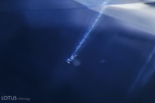 A tiny crystal and streamer appears to dive into an azure sapphire sea.